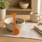 Halyvira orange pretzel ceramic spoon with a breakfast bowl